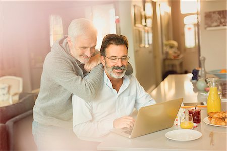 simsearch:6113-07906184,k - Male gay couple using laptop at breakfast kitchen counter Stock Photo - Premium Royalty-Free, Code: 6113-08947335