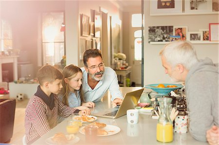 Male gay parents and children using laptop at breakfast kitchen counter Stock Photo - Premium Royalty-Free, Code: 6113-08947339