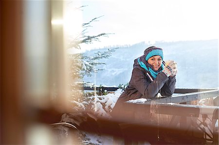 simsearch:6113-06899345,k - Portrait smiling female skier drinking hot cocoa on sunny cabin balcony Stock Photo - Premium Royalty-Free, Code: 6113-08947429