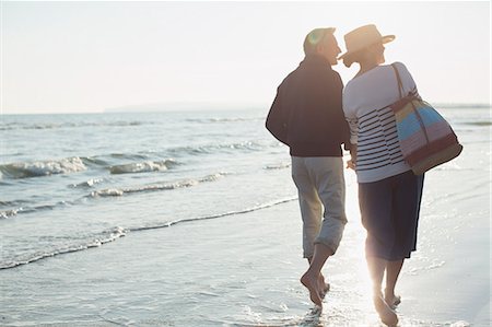 simsearch:6113-07589470,k - Barefoot mature couple walking on sunset beach Stock Photo - Premium Royalty-Free, Code: 6113-08985692