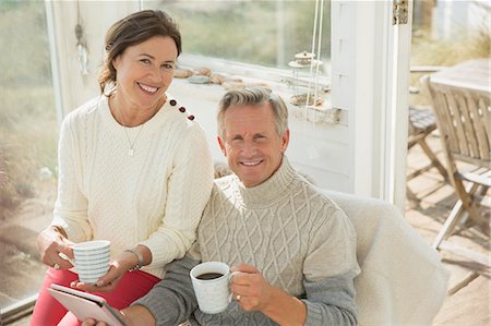 simsearch:6113-07762308,k - Portrait smiling mature couple using digital tablet and drinking coffee on sun porch Stock Photo - Premium Royalty-Free, Code: 6113-08985788