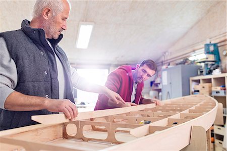 Male carpenters assembling wood boat in workshop Foto de stock - Sin royalties Premium, Código: 6113-08985861