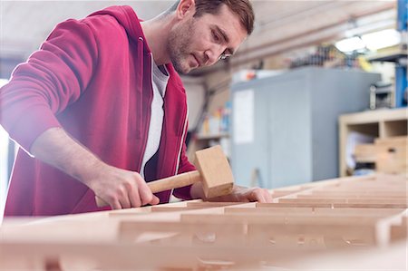 simsearch:6115-07109879,k - Male carpenter using wood mallet on boat in workshop Stock Photo - Premium Royalty-Free, Code: 6113-08985873
