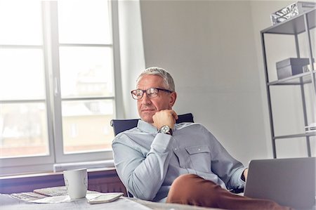 simsearch:649-07119200,k - Confident, pensive businessman with laptop looking away in office Stock Photo - Premium Royalty-Free, Code: 6113-08985894