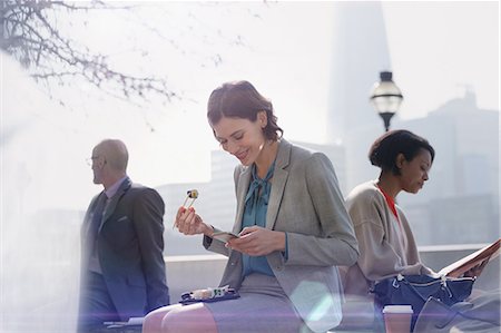 simsearch:6113-06899131,k - Businesswoman eating sushi on lunch break and using cell phone in sunny urban park Stock Photo - Premium Royalty-Free, Code: 6113-08986057