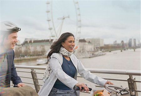simsearch:6113-07543572,k - Smiling, carefree couple bike riding on bridge near Millennium Wheel, London, UK Foto de stock - Sin royalties Premium, Código: 6113-08986062