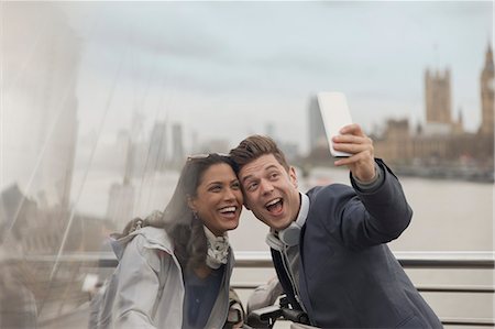 simsearch:6113-07648679,k - Playful couple tourists taking selfie with camera phone on bridge, London, UK Stock Photo - Premium Royalty-Free, Code: 6113-08986078