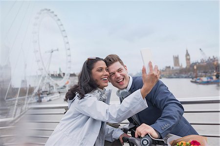simsearch:6113-06498180,k - Smiling couple tourists taking selfie with camera phone on bridge near Millennium Wheel, London, UK Stock Photo - Premium Royalty-Free, Code: 6113-08986082