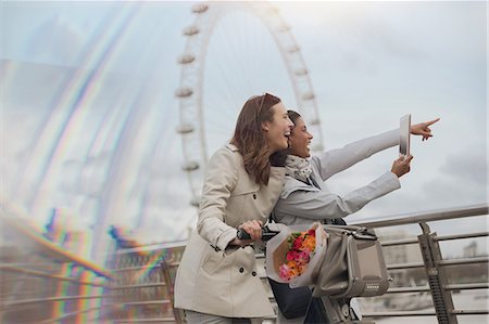 simsearch:6113-07147381,k - Female tourists with bicycle using digital tablet camera near Millennium Wheel, London, UK Stock Photo - Premium Royalty-Free, Code: 6113-08986001