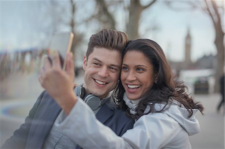 simsearch:632-07674444,k - Smiling couple taking selfie with camera phone in urban park Stock Photo - Premium Royalty-Free, Code: 6113-08986002