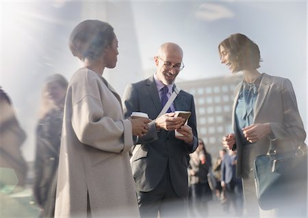 Business people talking, using cell phone and drinking coffee on urban street Stock Photo - Premium Royalty-Free, Code: 6113-08986025