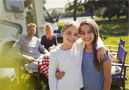 simsearch:649-07803505,k - Portrait smiling sisters hugging outside sunny motor home Stock Photo - Premium Royalty-Free, Code: 6113-08909843