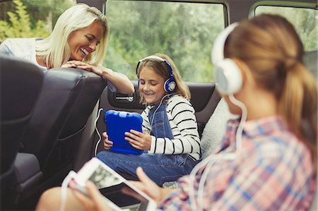 simsearch:6113-07730567,k - Mother watching daughters with headphones using digital tablets in back seat of car Stock Photo - Premium Royalty-Free, Code: 6113-08909861