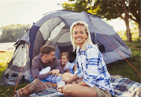 Portrait smiling mother drinking coffee with family at campsite tent Stock Photo - Premium Royalty-Free, Code: 6113-08909866