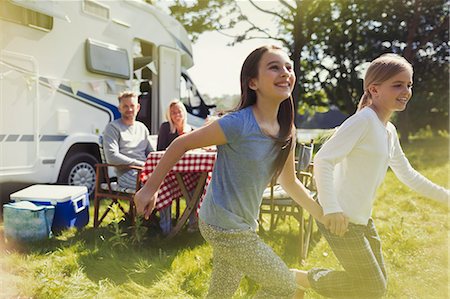 simsearch:6113-08393683,k - Playful sisters running and holding hands outside sunny motor home Stock Photo - Premium Royalty-Free, Code: 6113-08909879