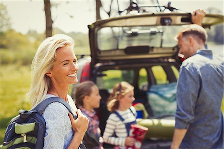 simsearch:6113-06754093,k - Smiling woman with backpack preparing for hike with family outside car Foto de stock - Sin royalties Premium, Código: 6113-08909883