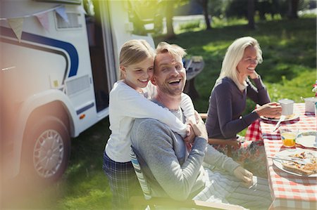 rv travel - Happy, affectionate father and daughter hugging outside sunny motor home Stock Photo - Premium Royalty-Free, Code: 6113-08909959