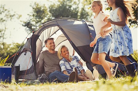 simsearch:6113-07242296,k - Parents watching happy daughters running around sunny campsite tent Stock Photo - Premium Royalty-Free, Code: 6113-08909907