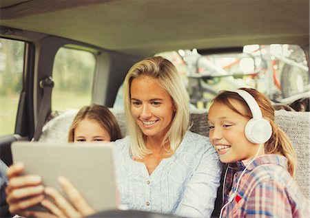 simsearch:6113-07730567,k - Mother and daughters watching video on digital tablet in back seat of car Stock Photo - Premium Royalty-Free, Code: 6113-08909914