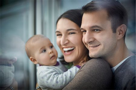 simsearch:6113-06498556,k - Smiling happy parents holding baby daughter Stock Photo - Premium Royalty-Free, Code: 6113-08910048