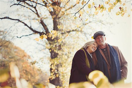 simsearch:6108-06166561,k - Affectionate senior couple hugging in sunny autumn park Foto de stock - Sin royalties Premium, Código: 6113-08910079