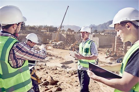 Construction workers and engineers meeting at sunny construction site Stock Photo - Premium Royalty-Free, Code: 6113-08910016