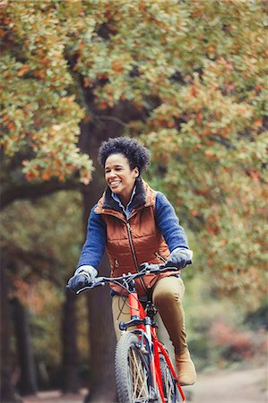 simsearch:6113-08321095,k - Smiling woman bike riding in autumn park Stock Photo - Premium Royalty-Free, Code: 6113-08910170