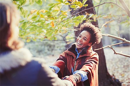 simsearch:700-06553388,k - Happy woman holding hands with boyfriend in sunny autumn park Stock Photo - Premium Royalty-Free, Code: 6113-08910199