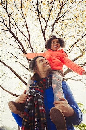 simsearch:649-05657717,k - Father carrying enthusiastic daughter on shoulders below autumn tree in park Foto de stock - Sin royalties Premium, Código: 6113-08910118