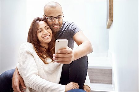 simsearch:6113-06899638,k - Smiling couple with camera phone taking selfie on stairs Stock Photo - Premium Royalty-Free, Code: 6113-08910243