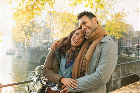 simsearch:6113-07543572,k - Laughing young couple hugging on autumn bridge over canal in Amsterdam Foto de stock - Sin royalties Premium, Código: 6113-08927653