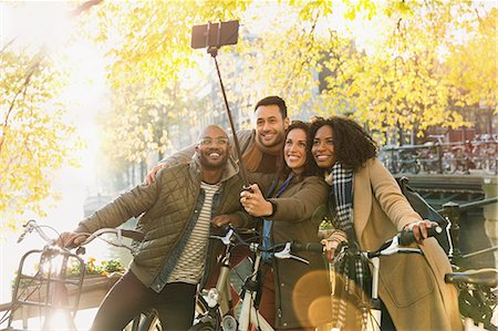 simsearch:6113-06498180,k - Smiling friends with bicycle taking selfie with selfie stick on urban bridge Stock Photo - Premium Royalty-Free, Code: 6113-08927656