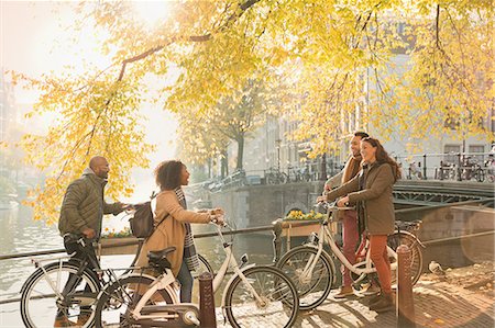 european vacation - Friends with bicycles along sunny autumn canal in Amsterdam Stock Photo - Premium Royalty-Free, Code: 6113-08927664