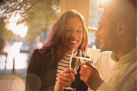 simsearch:6113-07543617,k - Smiling, romantic couple toasting champagne glasses in restaurant Stock Photo - Premium Royalty-Free, Code: 6113-08927684