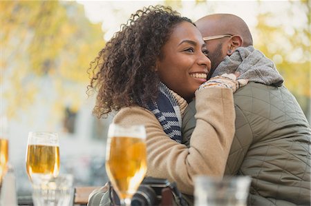 simsearch:6113-07543549,k - Smiling couple hugging and drinking beer at sidewalk cafe Stock Photo - Premium Royalty-Free, Code: 6113-08927686