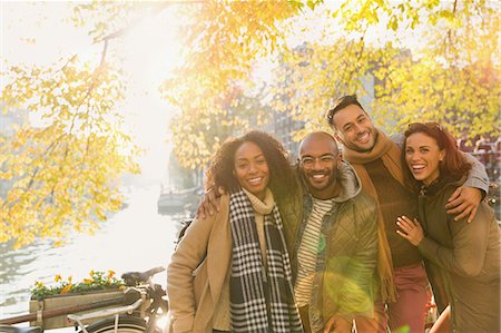 simsearch:6113-07565751,k - Portrait smiling friends hugging at sunny autumn canal Stock Photo - Premium Royalty-Free, Code: 6113-08927632