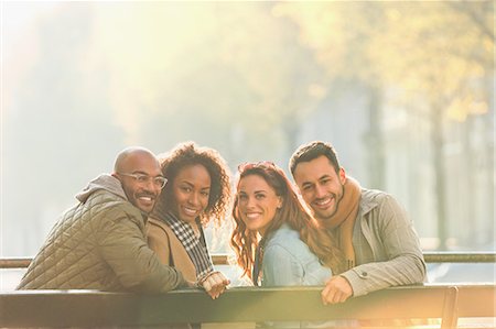 simsearch:6113-07565751,k - Portrait smiling young couple friends on sunny autumn bench Stock Photo - Premium Royalty-Free, Code: 6113-08927773