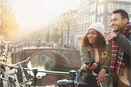Young couple with bicycles on urban bridge over canal, Amsterdam Stock Photo - Premium Royalty-Free, Code: 6113-08927727