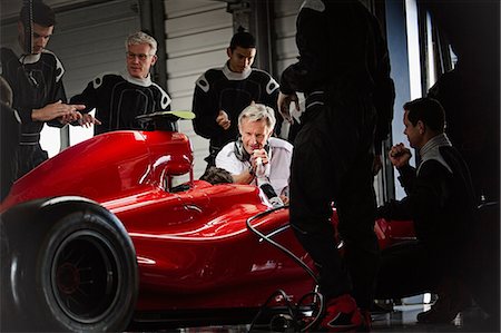 Manager and pit crew working on formula one race car in dark repair garage Photographie de stock - Premium Libres de Droits, Code: 6113-08927892