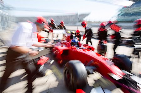 Pit crew replacing tires on formula one race car in pit lane Stock Photo - Premium Royalty-Free, Code: 6113-08927961