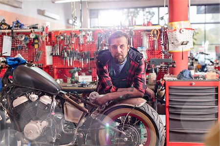 portraits - Portrait serious, confident motorcycle mechanic in workshop Photographie de stock - Premium Libres de Droits, Code: 6113-08927982