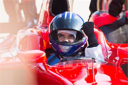 simsearch:6113-07588662,k - Formula one race car driver in helmet gesturing, celebrating victory Stock Photo - Premium Royalty-Free, Code: 6113-08927903