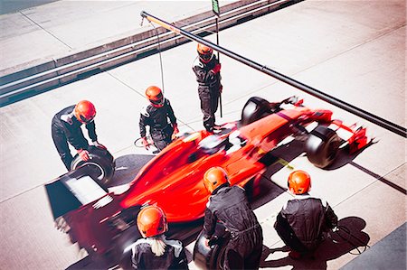 simsearch:700-00546343,k - Pit crew replacing tires on formula one race car in pit lane Stock Photo - Premium Royalty-Free, Code: 6113-08927904