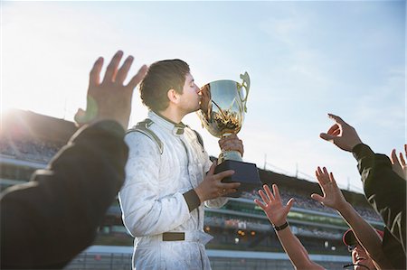 simsearch:6113-07542775,k - Formula one racing team cheering around driver kissing trophy, celebrating victory Stock Photo - Premium Royalty-Free, Code: 6113-08927908