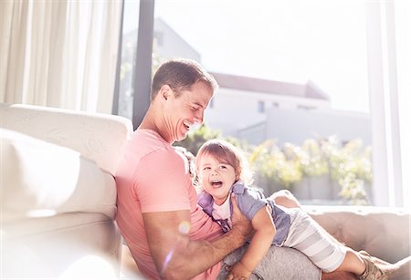 simsearch:649-07437107,k - Affectionate father holding baby son in sunny living room Stock Photo - Premium Royalty-Free, Code: 6113-08928047