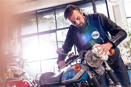 Male motorcycle mechanic wiping motorcycle in workshop Stock Photo - Premium Royalty-Free, Code: 6113-08928019
