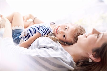 simsearch:6113-07543218,k - Portrait smiling daughter laying on top of mother Stock Photo - Premium Royalty-Free, Code: 6113-08928030