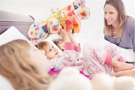 simsearch:640-06963757,k - Mother watching daughter playing with stuffed animal on bed Stock Photo - Premium Royalty-Free, Code: 6113-08928039