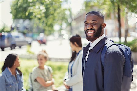 Portrait smiling businessman with backpack in urban park Stock Photo - Premium Royalty-Free, Code: 6113-09058440