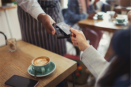 Customer with credit card paying worker with contactless payment in cafe Foto de stock - Sin royalties Premium, Código: 6113-09058471